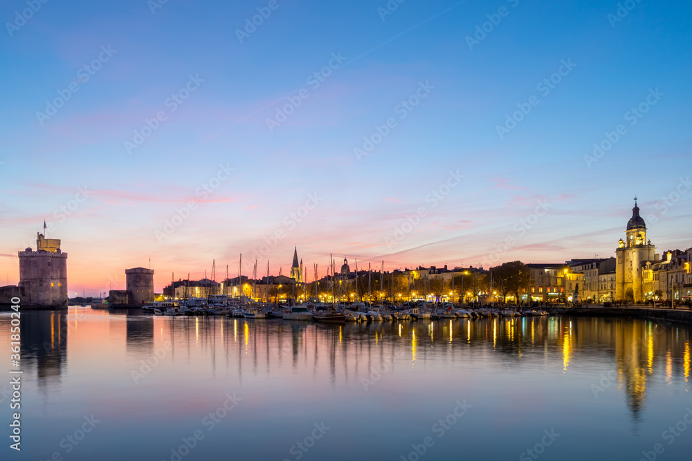 Panoramic view of the old harbor of La Rochelle at sunset with its famous old towers. beautiful pastel color sky