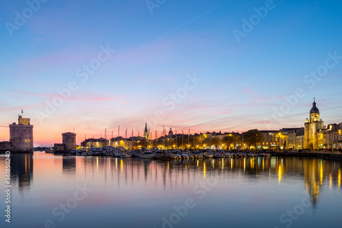 Panoramic view of the old harbor of La Rochelle at sunset with its famous old towers. beautiful pastel color sky © mathilde