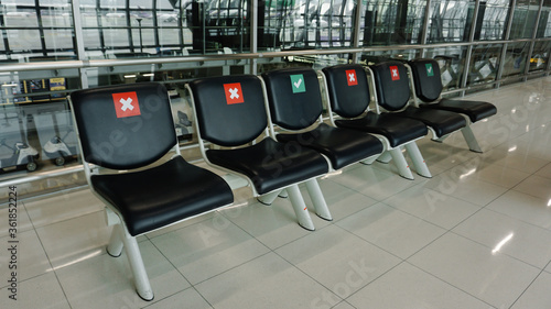 Social distance concept. A row of public chairs with an indication of where it is possible to sit to maintain the social safety distance during the period of the cover-19 coronavirus pandemic