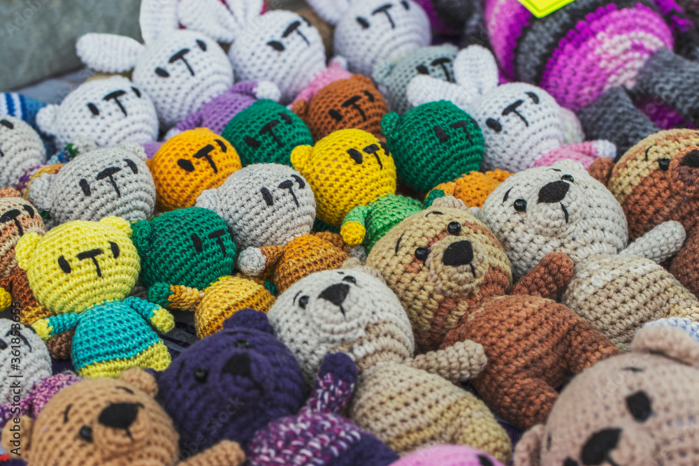 Knitted toys are sold on a tray in a city park. Creativity and needlework from yarn.