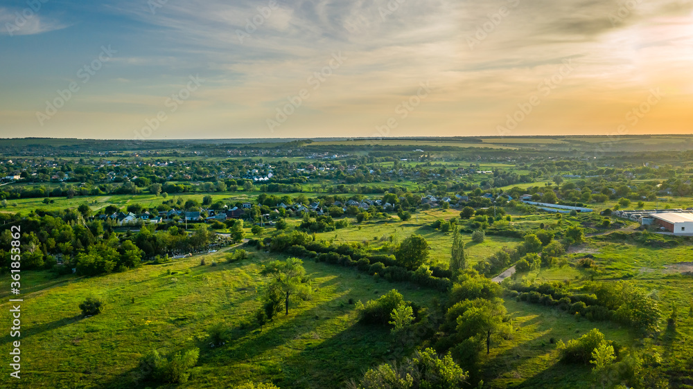 A small village in Ukraine in summer day. Scenic aerial view of the Ukrainian countryside landscape from high. Natural green foliage background.