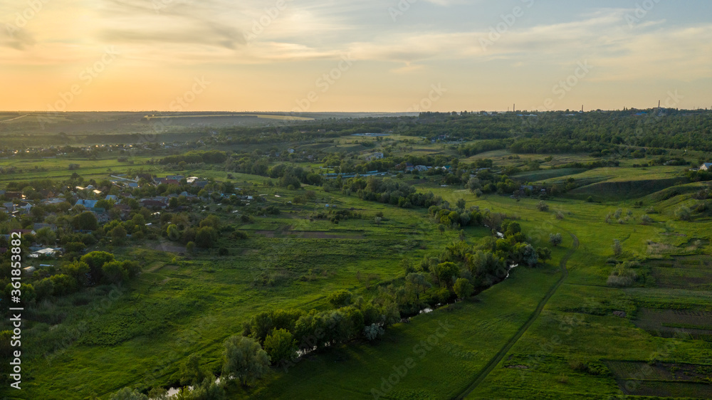 Scenic aerial view of the Ukrainian countryside landscape from high. A small village in Ukraine in summer day. Natural green foliage background.