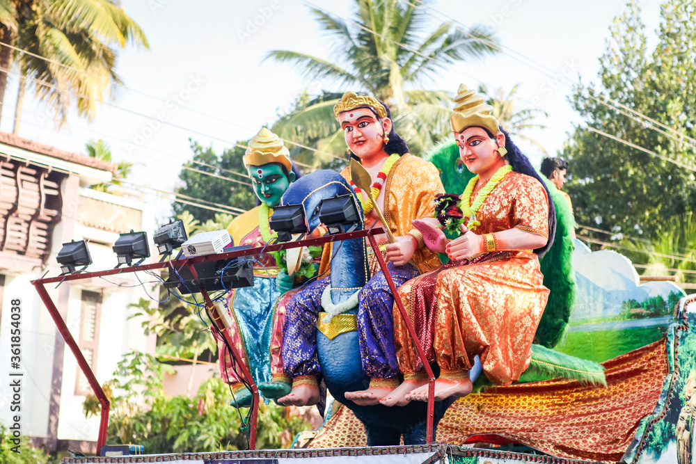 different big statues of traditional Indian gods ride on open platform at religion feast