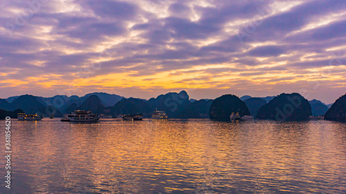 tourist boats lit up at sunset on Halong Bay, Vietnam 