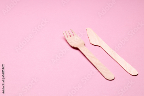 eco-friendly disposable utensills concept. bamboo or wooden cutlery over color background.