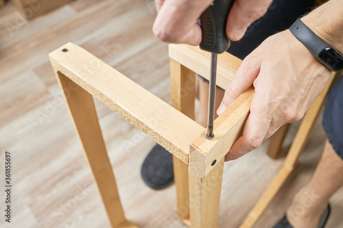 diy wood working at home. wooden planks with screwdriver. woodwork. domestic life. male person repair or fixing furniture.