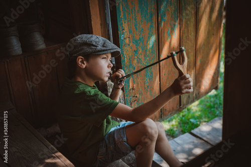 Valokuva young boy with slingshot shooting