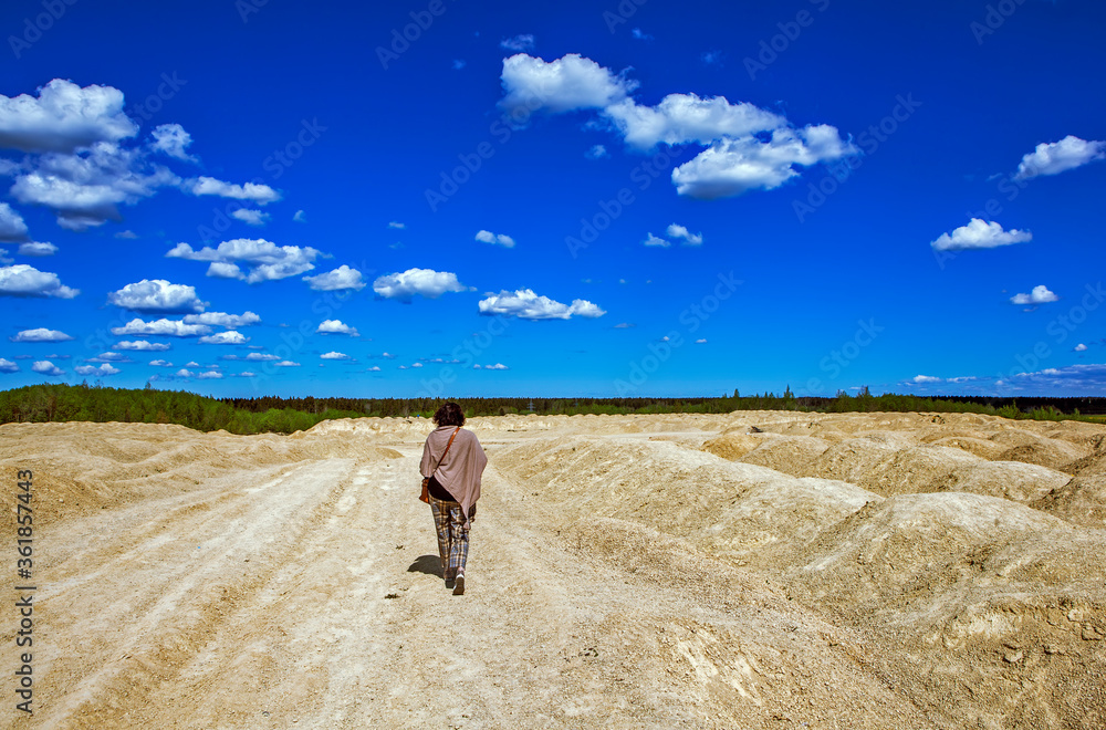 Obraz premium Elegant woman on the background of the Martian landscape. Bornitsky quarry. The village of New Khinkolovo, Gatchinsky district, Leningrad region. Russia