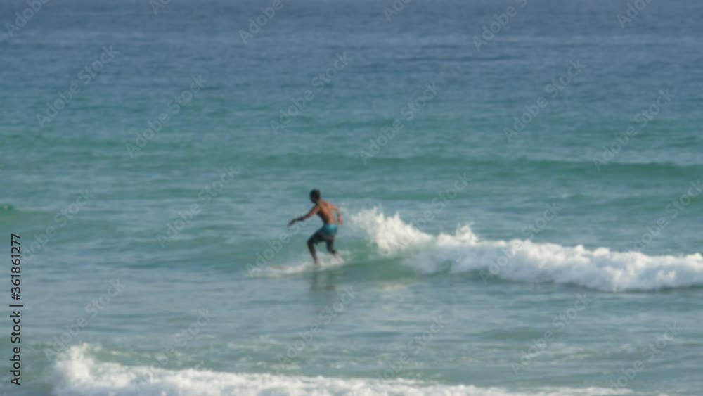 blur surfers with surfboard on the sea in sunny day blur surfers with surfboard on the sea in sunny day