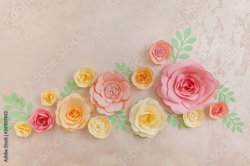 Decorative background from paper handmade flowers on the wall.