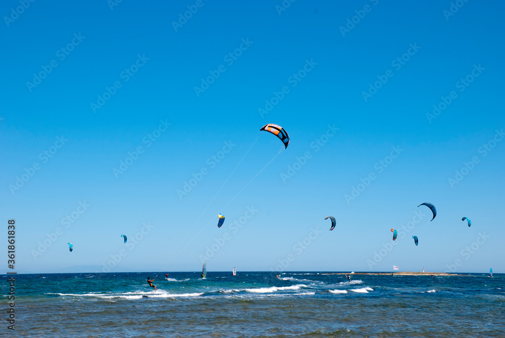 Athens, Greece, July 2020: Windsurfing and Kite Surfing on a very sunny day Athens, Greece, July 2020: Windsurfing and Kite Surfing on a very sunny day