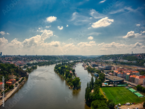 aerial view of Vysehrad church in Prague on a hot summer day with boats and people enjoying Vltava riverbank