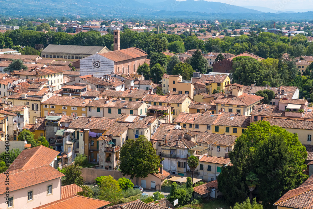 Lucca, Italy - August 14, 2019: Panoramic view of Lucca from Guinigi Tower balcony with oak trees, Tuscany, Italy