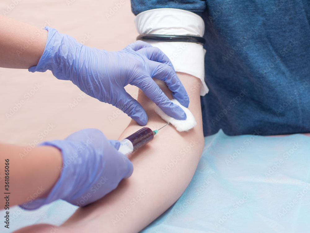 The doctor take blood from patient's hand. Blue gloves. Close up The doctor take blood from patient's hand. Blue gloves. Close up