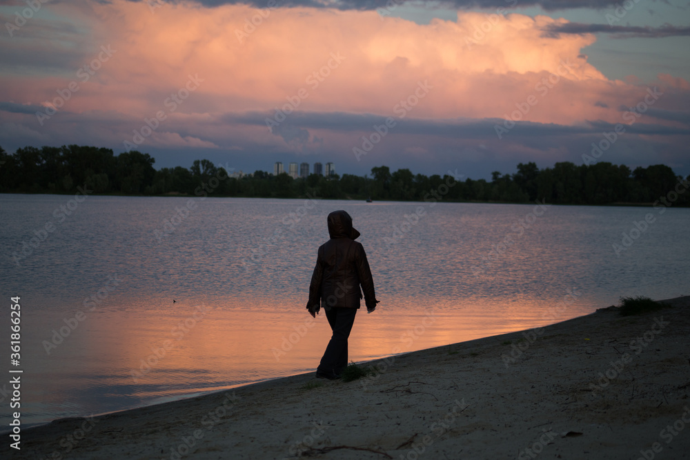 Fototapeta premium Silhouette of a man on a sunset background in the sity