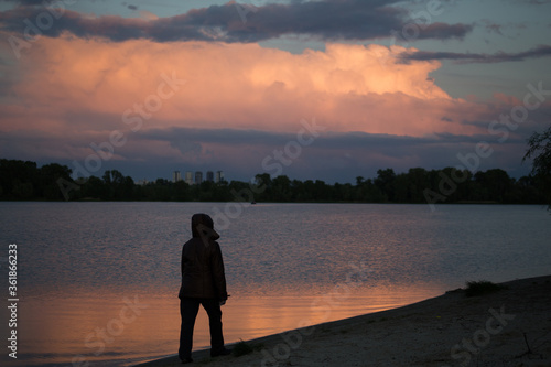 Silhouette of a man on a sunset background in the sity