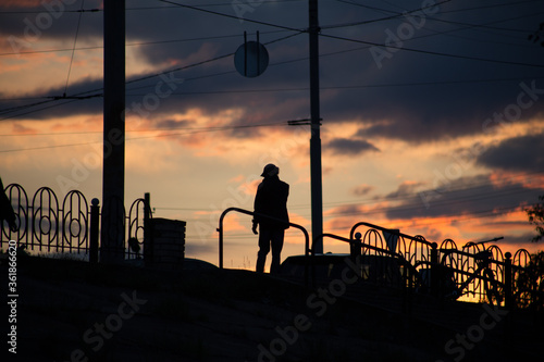 Silhouette of a man on a sunset background in the sity