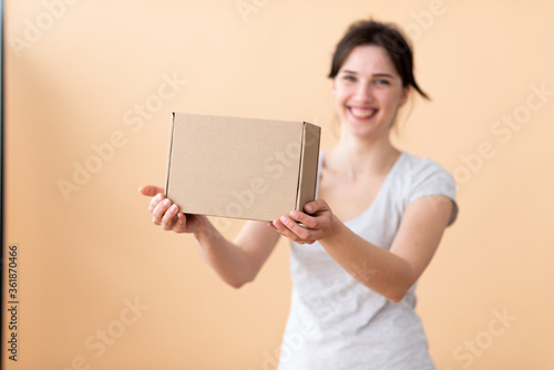 Happy girl showing craft box in her hands and smiling joyfully in the background. Box in focus with free space for text.
