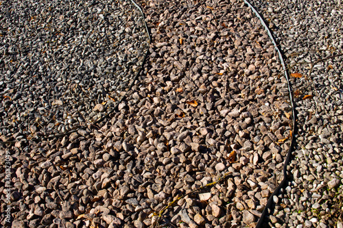 Tela Metal edging separating different colors of gravel in a park