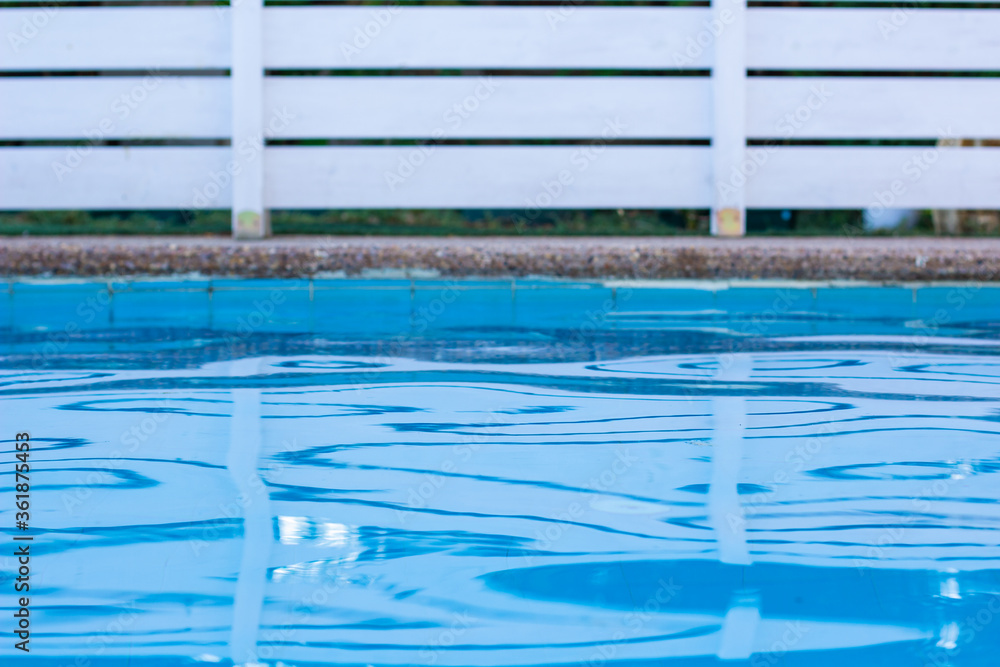 Obraz premium soft focus swimming pool side relaxation space blue water and garden white wooden deck fence background yard view
