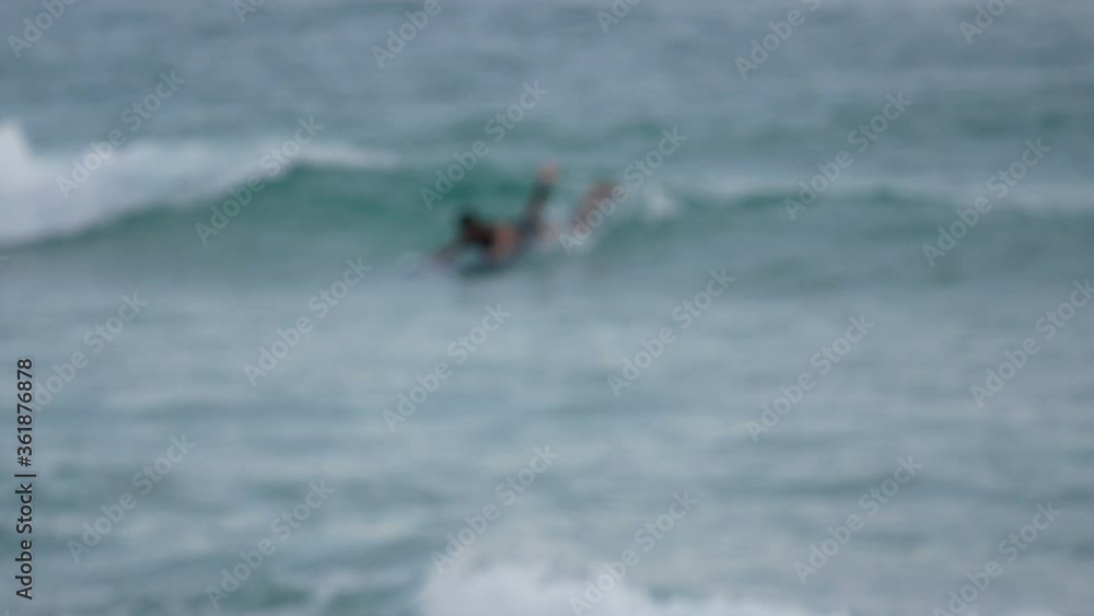 blur surfers with surfboard on the sea in sunny day blur surfers with surfboard on the sea in sunny day