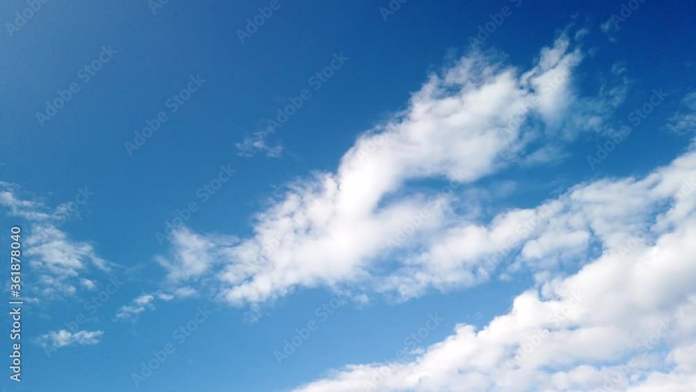 Time-lapse of fluffy clouds moving over blue sky in a sunny day. Nature screensaver timelapse with copy space. Time-lapse of fluffy clouds moving over blue sky in a sunny day. Nature screensaver timelapse with copy space.