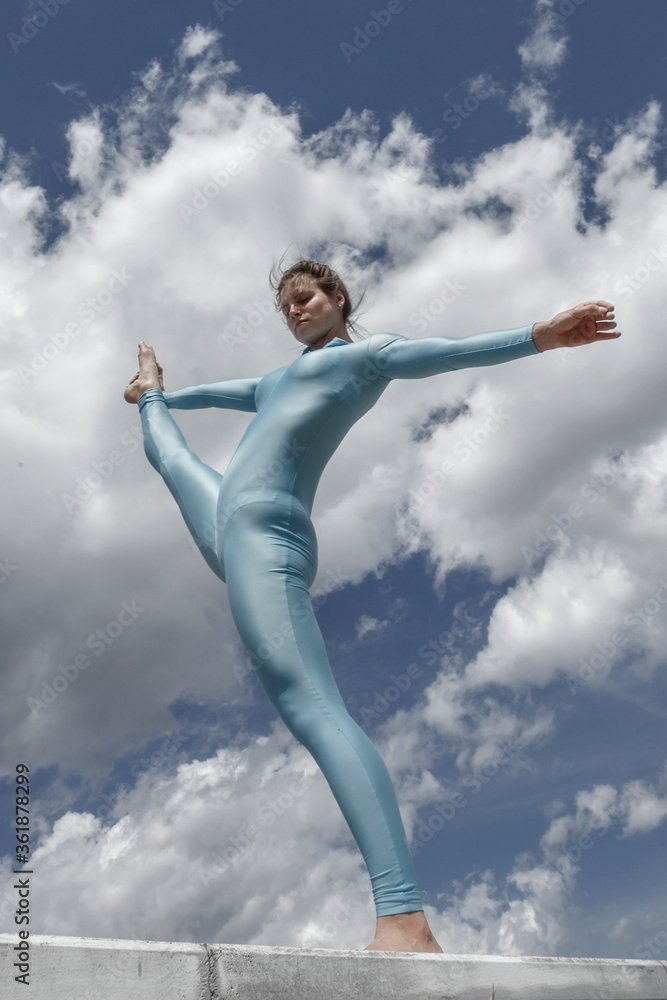 acrobat girl in a blue suit on the street