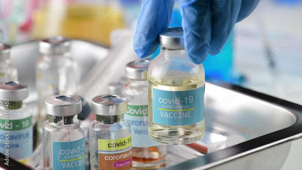 hand of scientist doctor holding vial ampoule bottle human use vaccine syringe injection coronavirus covid19 at hospital lab. Researcher in laboratory Try to extract vaccine for virus covid19 Success. hand of scientist doctor holding vial ampoule bottle human use vaccine syringe injection coronavirus covid19 at hospital lab. Researcher in laboratory Try to extract vaccine for virus covid19 Success.