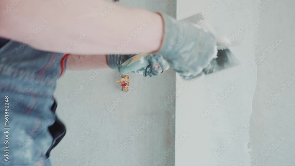 Man worker is making repairing in the apartment by putting putty on the walls. Construction house. Man worker is making repairing in the apartment by putting putty on the walls. Construction house.