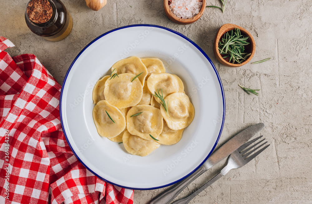 Traditional italian ravioli with rosemary and parmesan served onon an enamel plates. Italian pasta. Traditional italian ravioli with rosemary and parmesan served onon an enamel plates. Italian pasta.
