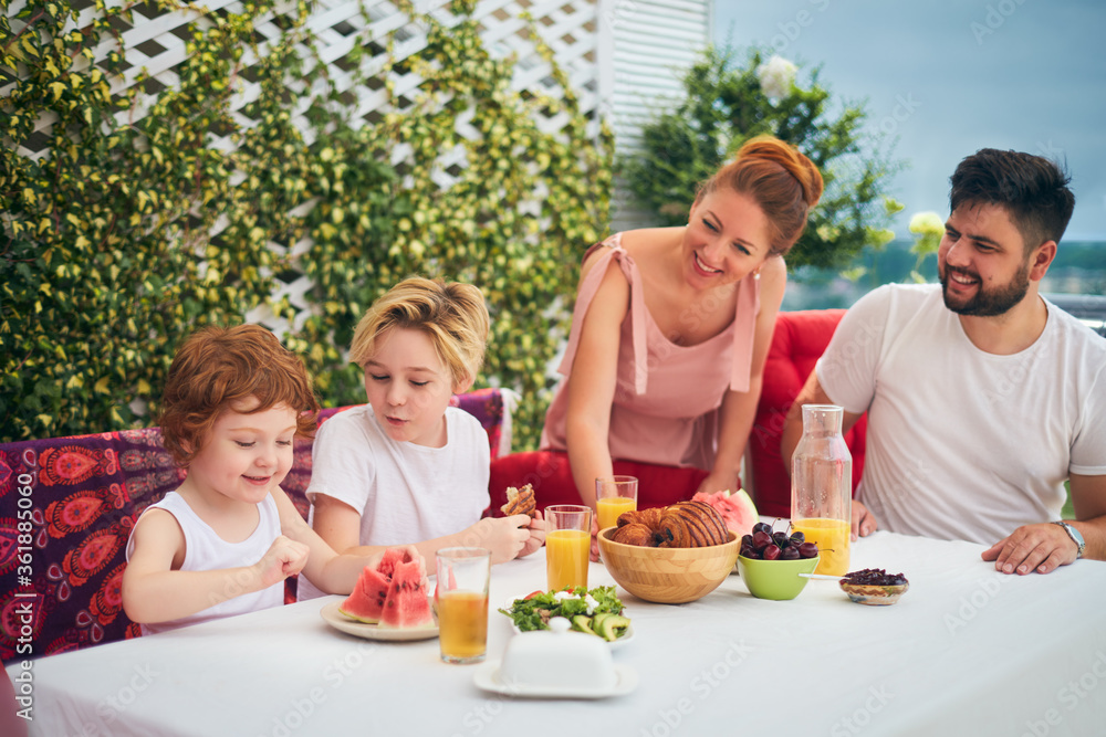happy family having lunch on rooftop patio at home