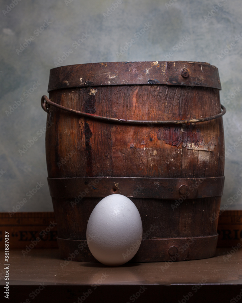 Fototapeta premium egg next to a vintage wooden bucket