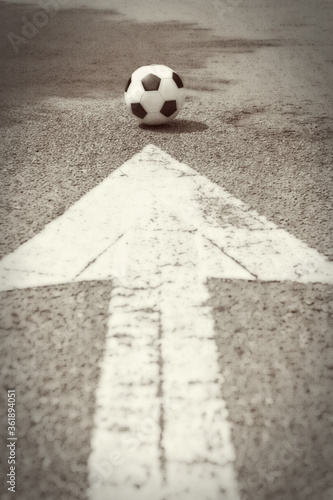 An arrow on the road pointing to soccer ball