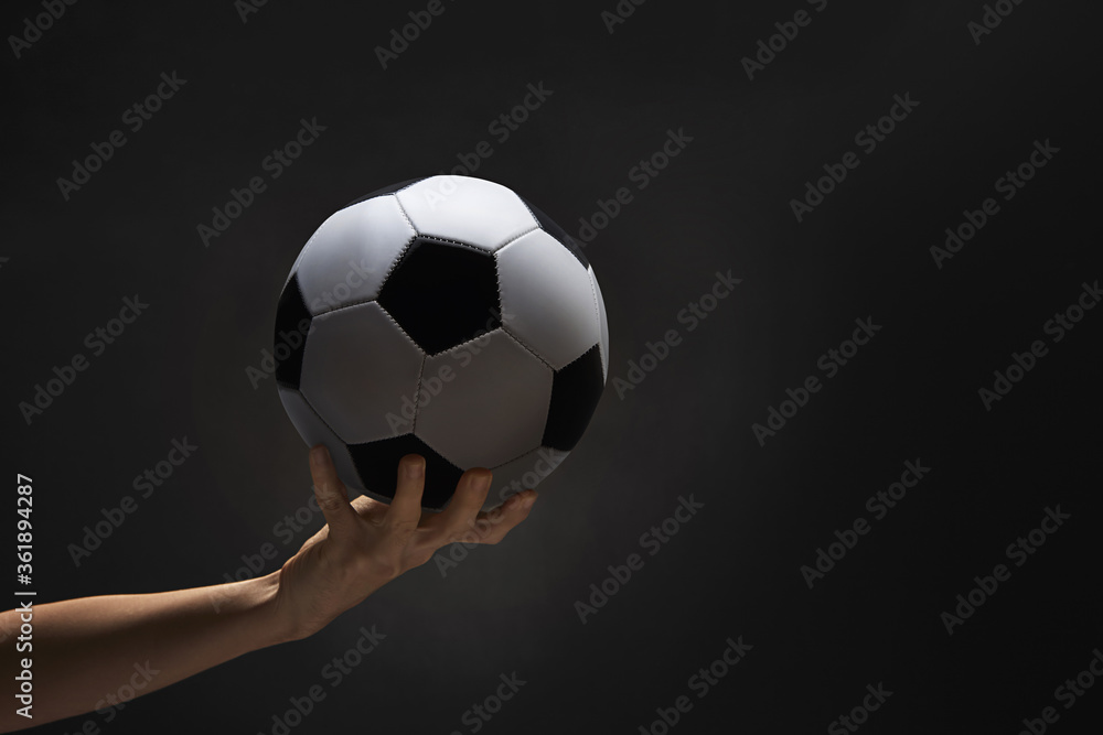 A hand holding a soccer ball A hand holding a soccer ball