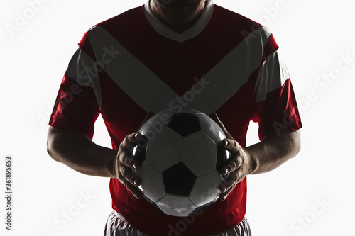 A soccer player holding a soccer ball