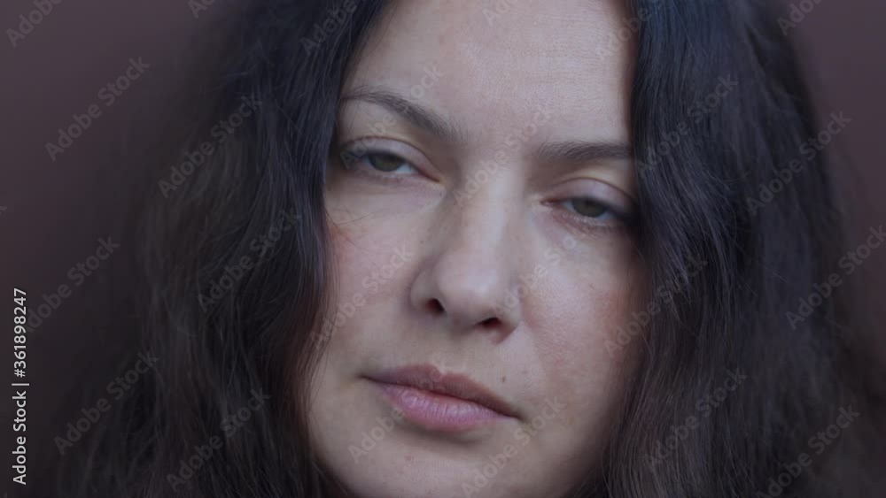 Adult woman portrait on brown background. Close up of brunette woman face. Attractive woman thinking, looking at camera. Female person with long hair beautiful brown eyes. Adult woman portrait on brown background. Close up of brunette woman face. Attractive woman thinking, looking at camera. Female person with long hair beautiful brown eyes.