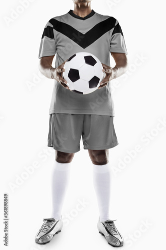 Fototapeta Naklejka Na Ścianę i Meble -  A soccer player holding a ball