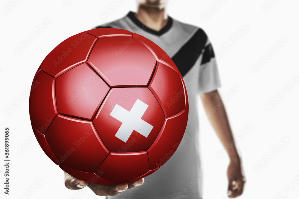 A soccer player holding Switzerland soccer ball