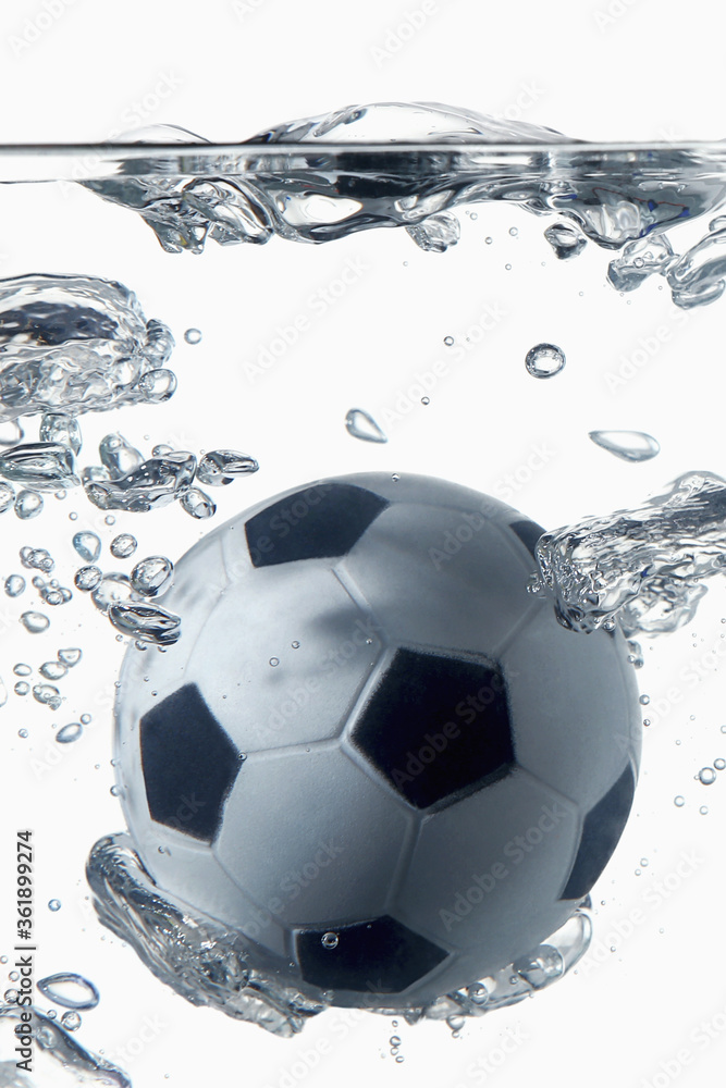 Fototapeta premium Soccer ball splashing into water