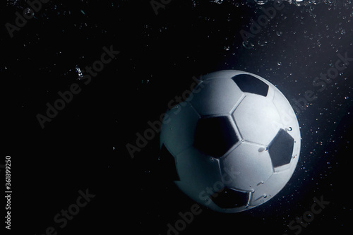 Soccer ball splashing into water © ImageHit