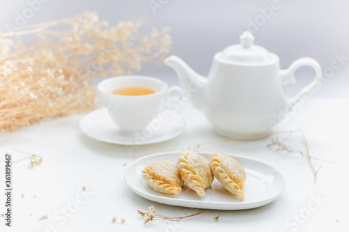 Thai traditional pastry curry puffs with tea and teapot.