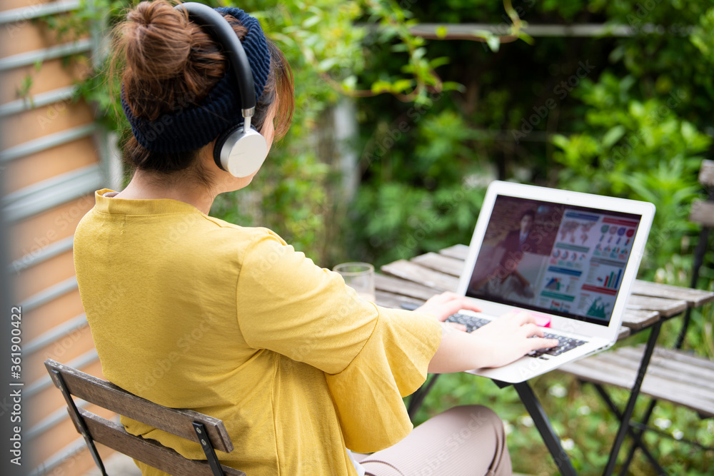 自宅の庭で職場のweb会議に参加する女性 Stock Photo Adobe Stock 自宅の庭で職場のweb会議に参加する女性 Stock Photo Adobe Stock