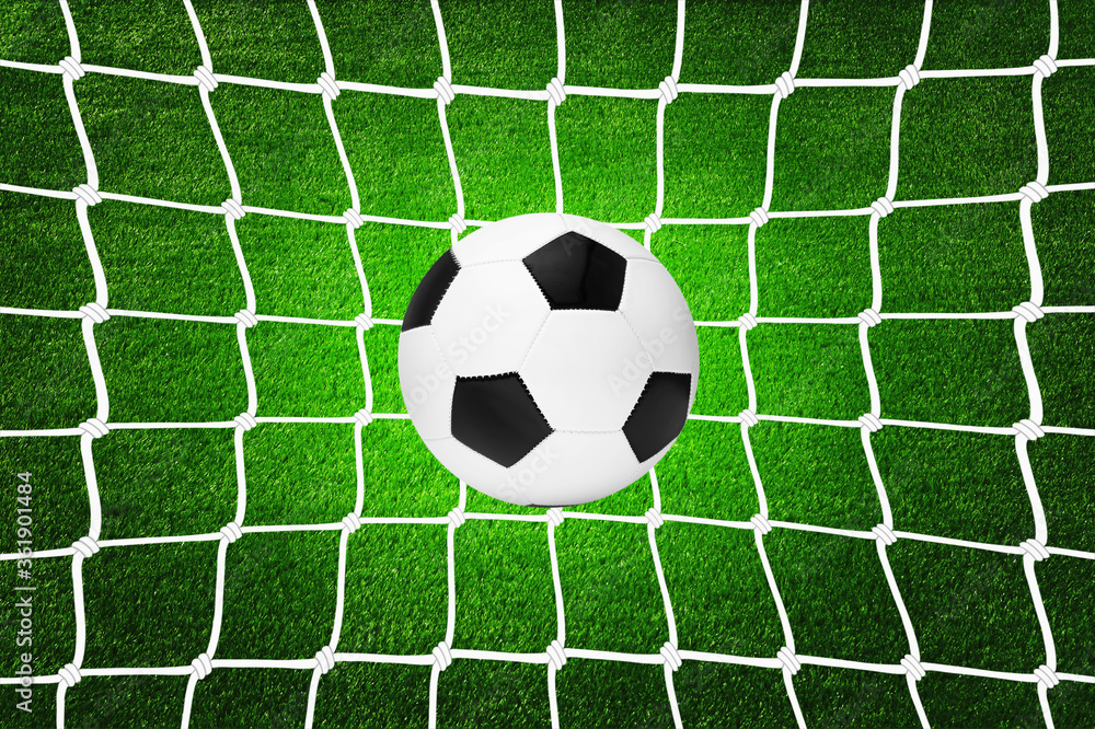 A soccer ball in goal net A soccer ball in goal net