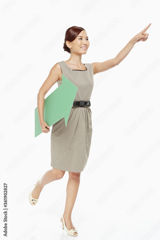 Businesswoman holding a green arrow, facing left Businesswoman holding a green arrow, facing left