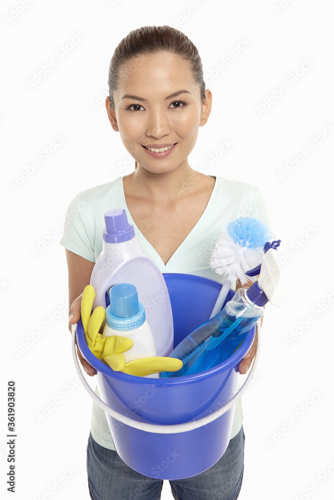 Woman holding a bucket filled with cleaning supplies Woman holding a bucket filled with cleaning supplies