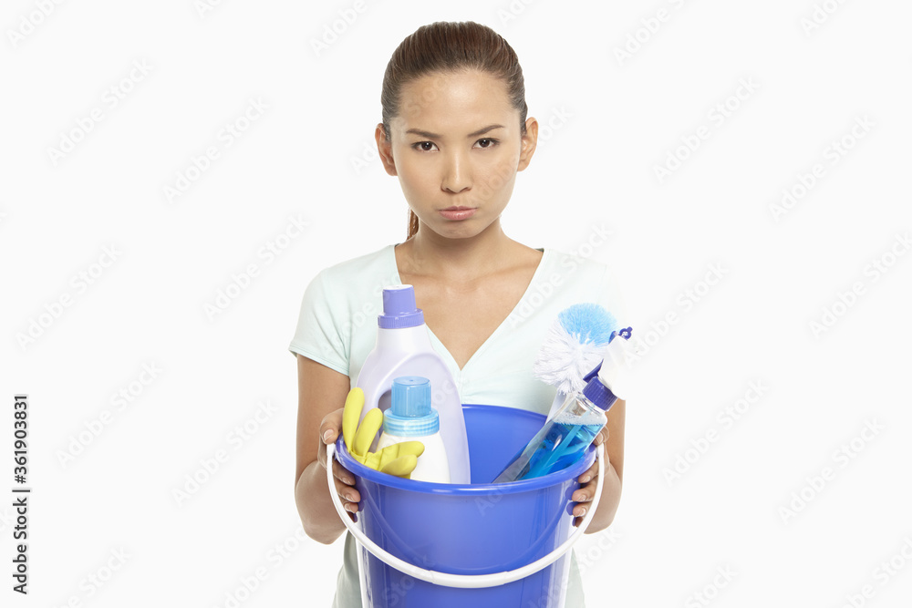 Woman holding a bucket filled with cleaning supplies Woman holding a bucket filled with cleaning supplies