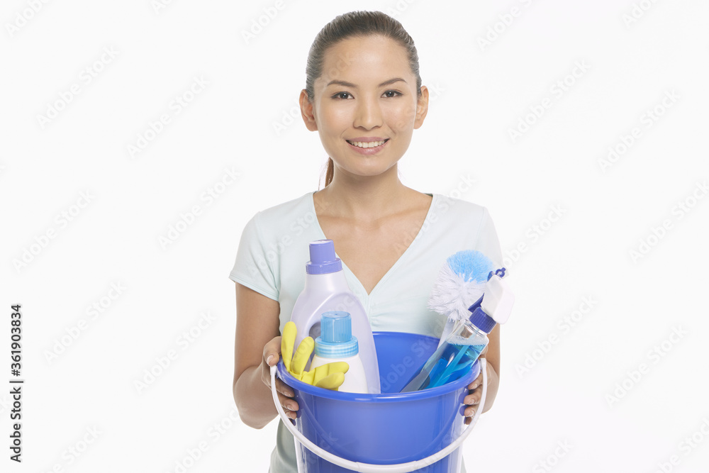 Woman holding a bucket filled with cleaning supplies Woman holding a bucket filled with cleaning supplies