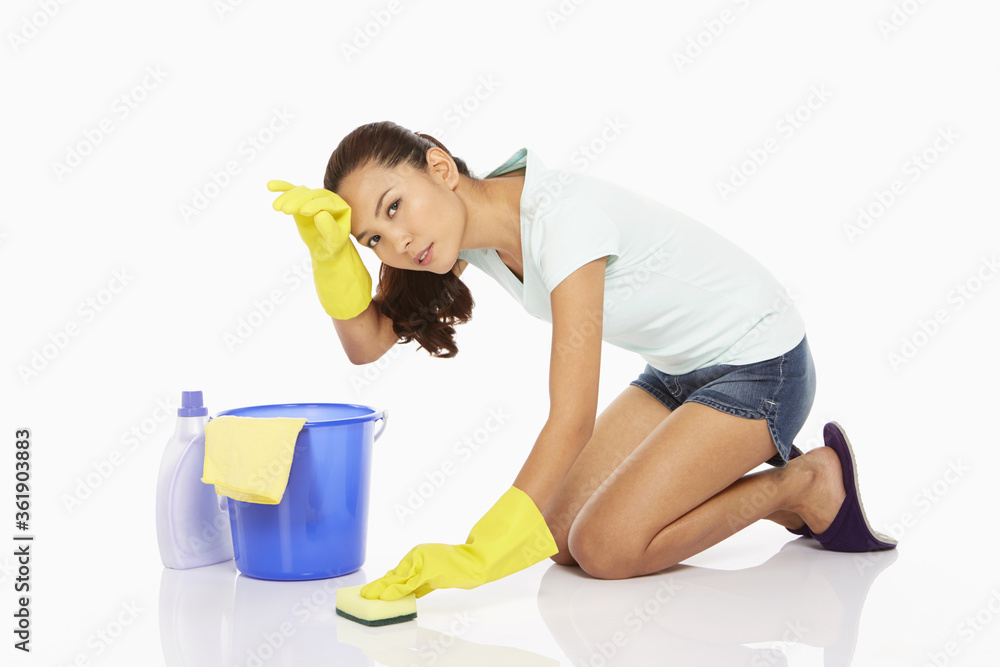 Woman scrubbing the floor, feeling exhausted Woman scrubbing the floor, feeling exhausted