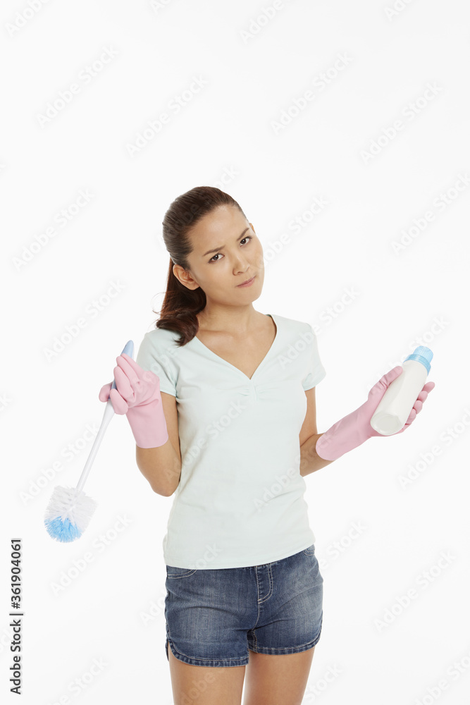 Woman holding up a detergent bottle and a brush Woman holding up a detergent bottle and a brush