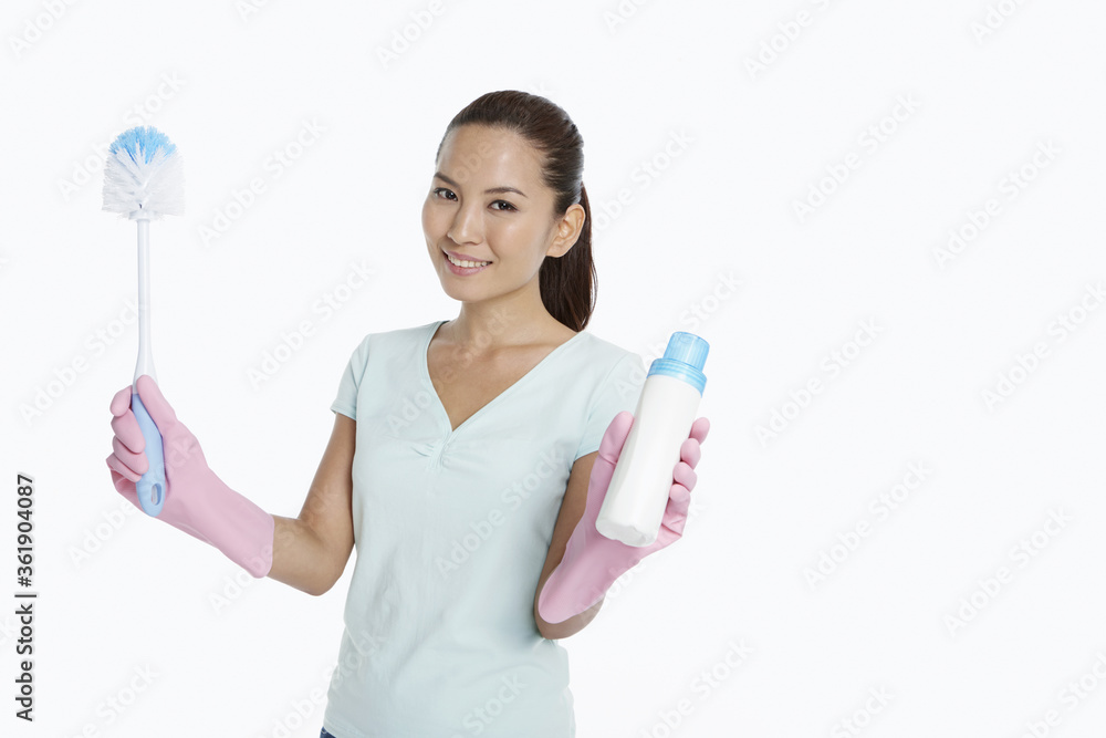 Woman holding up a detergent bottle and a brush Woman holding up a detergent bottle and a brush